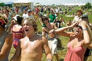 Damian Conrad-Davis, left, of Lamoni, Iowa, and Abby Hernandez, right, of Kansas City, Mo., sing along to State Radio on June 7 at the Wakarusa Music and Camping Festival at Clinton Lake. Festival organizer Brett Mosiman has accused the Kansas Department of Wildlife and Parks of discriminating against the 'hippie' crowd that attends the event by charging more, and he said the music festival may not return to Clinton State Park as a result.