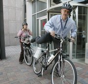Emory University employees David Knight and Casey Brinsfield ride bicycles borrowed from the school&squot;s bank of loaner bicycles to a meeting July 18 on the school&squot;s campus in Atlanta. The university is pushing its $250,000 "Bike Emory" initiative, launched a year ago in hopes of convincing students and faculty to choose bikes over cars.