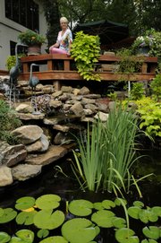Kirsten Rosengaard's sloping yard creates a terraced space for a multilevel deck and sweeping view of colorful flowers and a water garden.