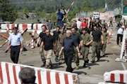 Georgian officials, front left and right, escort 12 released Georgian soldiers Thursday on the Abkhazian-Georgian border. In a CNN interview Thursday, Russian Prime Minister Vladimir Putin accused the United States of being responsible for the recent violence in Georgia and hinted at a potential domestic U.S. political motive behind the fighting.