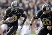 Missouri wide receiver Jeremy Maclin (9) looks for a hole as he gets blocking help from teammate Chase Daniel in this file photo. Maclin and Daniel have become a dangerous 1-2 punch for the Tigers.