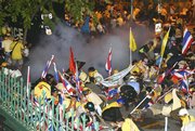 Thai police shoot tear gas into anti-government protesters Friday in Bangkok, Thailand. Police muscled into crowds of anti-government protesters occupying the prime minister's office compound Friday, sparking scuffles that left several people with minor injuries.