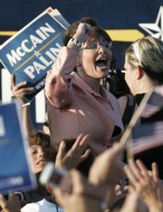 Republican vice presidential candidate, Alaska Gov. Sarah Palin, pumps her fist as she walks toward a bus at a campaign stop Saturday in Washington, Pa.