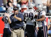 Coach Bill Belichick, left, claps after the Patriots defense stopped Kansas City from scoring with less than a minute left in the fourth quarter.