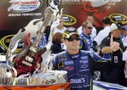 Jimmie Johnson poses with the winner's trophy in victory lane. Johnson won the Chevy Rock & Roll 400 NASCAR Sprint Cup on Sunday at the Richmond International Raceway in Richmond, Va.
