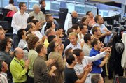 European Organization for Nuclear Research (CERN) scientists applaud during the switch-on of the Large Hadron Collider, the world's largest particle collider, at CERN's control center in Geneva. The collider successfully completed its first major test Wednesday in what scientists hope is the next great step to understanding the makeup of the universe.