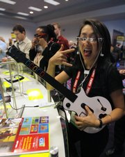 Judy Mellett of Toronto poses while playing a video game through Myvu's personal media viewer at the Consumer Electronics Show in Las Vegas in this Jan. 9 file photo.