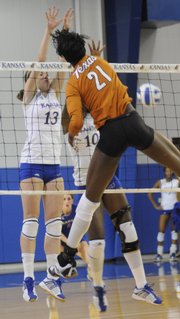 Kansas players Nicole Tate (13) and Brittany Williams (10) attempt to block a spike by Texas' Destinee Hooker on Saturday at the Horejsi Center.