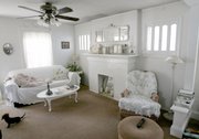 Walls and furniture painted white brighten the living room of Patty Kerr's Firestone Park bungalow in Akron, Ohio. Kerr's home is the embodiment of frugal fashion.