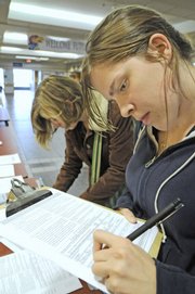 Shannon Craft, left, a Kansas University sophomore from Lawrence, and Kara Hudson, a junior from Wichita, register to vote on Tuesday at the Kansas Union. Voter registration has soared in Douglas County as the Nov. 4 general election approaches.