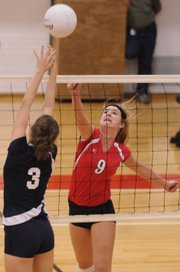 Lawrence High sophomore Mary Coldsnow lifts a shot over Manhattan High junior defender Shelbi Doehling during the first match of their home volleyball quad Tuesday, Oct. 14, 2008 at LHS.