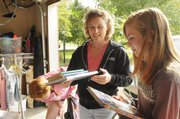 Susan Eagle, a housewife for 10 years, works with Girl Scout Paige Kellenberger, of Troop 7744, on a garage sale. The mother of two, Eagle spends a lot of time volunteering in the community.