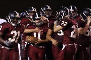 Lawrence's Clint Pinnick (11), is congratulated after a touchdown run. Lawrence defeated Olathe Northwest, 28-7, on Friday at Haskell Stadium.
