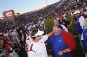 Kansas head coach Mark Mangino and Oklahoma head coach Bob Stoops come together for a congratulatory meeting after the game Saturday, Oct. 18, 2008 at Memorial Stadium in Norman, Oklahoma.