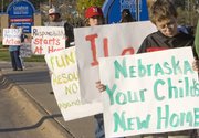 Protesters hold signs recently in front of the Creighton Medical Center in Omaha, Neb. Nebraska's current law allows anyone to leave a child as old as 18 at a state-licensed hospital without fear of prosecution.
