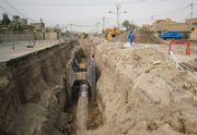 Iraqi men work last week on a planned sewage treatment system that is three years overdue in Fallujah, 40 miles west of Baghdad, Iraq. A new report shows the U.S. project has been troubled by violence, staggering waste, endless delay and U.S. and Iraqi incompetence.