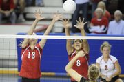 Lawrence High's Lillian Schonewise (13) and Jasmyn Turner (8) attempt to block the hit of Blue Valley West's Liz Buck. LHS lost to Blue Valley West, 25-22, 25-16, on Friday in the state tournament in Topeka.