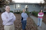 Above, from left, Brian Resnik, Marilyn Resnik and Karin Liles stand in front of their Topeka home Nov. 13, which was hit by a tornado 20 years ago. Below, Brian Resnik, then 12, pokes at a loose rafter as his parents, Bob and Marilyn, and sister Karin, then 10, survey the damage in a November 1988 file photo.