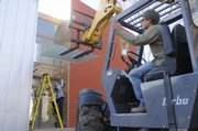 This house at 630 Walnut, gets a sturdy piece of glass over the front entrance a different approach as Ty Martin and Scott Trettel slowly place the heavy glass over the entrance.