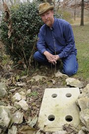 A Burblebox installed in the ground at a home in west Lawrence diverts rainwater away from the house from the downspout. Greg Frost, of Burblebox Systems of Lawrence, is pictured with his device.