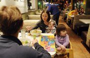 Kendra Kuhlman ends up holding 6-month-old Les as he finishes eating while daughter Keirn looks off into the small crowd of people with little interest in the rest of her meal. When the kids get to out of control, the parents pack up and head home.