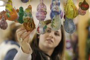 Jennifer Schwering, Lawrence, picks out some decorated gourd Christmas tree ornaments at the Pendleton's Country Market booth at the Holiday Farmer's Market at Knights of Columbus Hall, Saturday, Dec. 13, 2008. Schwering was shopping with her mother Barbara Schwering at the annual event.