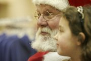 Larry Freeman, left, meets with Amelia Thies, 5, for a polaroid photo Saturday in Weaver’s, 901 Mass. Freeman, who has been Lawrence’s most famous Santa Claus for several decades, will appear in Weaver’s again from 1 to 4 p.m. today and for a few hours on Christmas Eve.