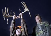 Chad Christie, right, of Baldwin city, shot a large buck within a quarter-mile of his house in early December. The 20-point buck will probably be recorded as one of the biggest ones ever shot in the state. Christie’s son Justin, 10, holds up the antlers outside their house on Dec. 17.