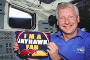 Hawley poses during a flight with a T-shirt from his alma mater, Kansas University, where he now teaches.