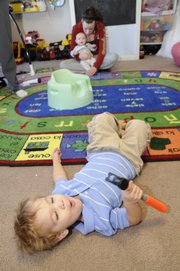 Two-year-old Sebastian Borjas rolls on the floor at his home and plays with a hammer - a soft children's hammer. Toddler-proofing a home can be a challenge for parents. Borjas' mom, who operates Boomer Babies Day Care, 2439 Via Linda Drive, has installed heavy duty electric socket covers and fenced off areas of her home to help keep Borjas safe.