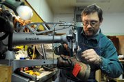 Matt Felke trims the thread after sewing a tear in a work boot that was brought in by a customer Tuesday, Dec. 23, 2008 in Great Bend, Kan. Felke has purchased Becker's Shoe Repair in Great Bend and works with Jerry Becker in learning the shoe repair trade.