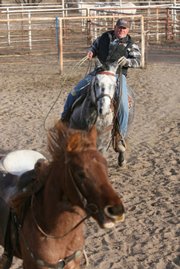 Charles "Bronc" Rumford pushes another horse around a pen as he rides his horse, Gunsmoke, Thursday, Jan. 8, 2009, on his farm near Abbyville, Kan. Rumford will be taking a full rodeo including horses, bulls, cowboys and cowgirls and also the arena equipment to Spain from Sept. 1 to Oct. 15.