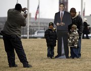 Billy Johnson, far left, of Charlotte, N.C., photographs General Mealer, right, with his grandsons Daryll Mealer, 7, second from left, and Jason Mealer, 6, with a cardboard cutout of President-elect Barack Obama on the National Mall in Washington, Monday, Jan. 19, 2009. The Mealers are from Carry, N.C.