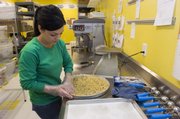 Rachel Bechtold presses out the chocolate chip dough for a giant sixteen-inch cookie. Eileen's Colossal Cookies opened up earlier this month.