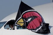 Capt. Bruce Meyer of Minneapolis holds a Arizona Cardinals flag outside the cockpit window as the team arrives at the Tampa International Airport for Super Bowl XLIII NFL football game on Monday, Jan. 26, 2009, in Tampa, Fla.