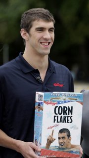 Michael Phelps poses with a cereal box during a news conference in this file photo from Sept. 25, 2008. Kellogg Co. has decided not to renew its sponsorship with Phelps, prompting marijuana advocates to cry foul.