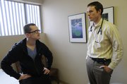 Patient Jason Kelich, KU graduate student from Overland Park, visits with Dr. David Dunlap at First Med and Walk-In Center, 2323 Ridge Court, on Friday. Dunlap has been at the clinic for five years and likes working there because he can provide care immediately. Walk-in clinics are popping up across the nation to provide immediate care for people.