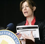 New Jersey Attorney General Anne Milgram holds a replica of a Ticketmaster Web page during a news conference in East Rutherford, N.J. Milgram on Monday announced a settlement with Ticketmaster that changes the way the company sells tickets nationwide over the Internet. The case stems from complaints received about ticket purchases for a Bruce Springsteen concert. Ticket seekers were redirected from the main Ticketmaster site to a subsidiary that charged more.