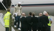 Former British resident Binyam Mohamed, second left, who has been held at Guantanamo Bay, steps from a plane Monday at Northolt military base in west London. Mohamed claims he was brutally tortured at a covert CIA site in Morocco. He has been freed from Guantanamo after nearly seven years.