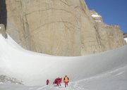 British Environment Minister Hilary Benn, in a yellow parka, joins other ministers and representatives from a dozen nations on a fact-finding visit to the area around Norway’s Troll Research Station on Monday, touring the ice sheet below the Judulsessen massif of rock towers in Antarctica. Scientists reported in Geneva on Wednesday that, in a warming world, Antarctic glaciers are accelerating their dumping of ice into the sea, raising ocean levels.