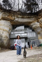 Marsaw, 9, plays with a family cat Thursday outside the home of Curt and Deborah Sleeper in Festus, Mo. The sleepers have put the house, built in a cave, on eBay as a backup in case they can’t meet a large payment due on the property.