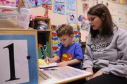Ray Bloxom, 4, works at a writing center with his teacher, Margo Aronovich, at Ballard Community Center, 708 Elm St. Ballard is a nonprofit organization affordable early education and life assistance for individuals and families. It is one of many organizations balancing diminishing funds and a greater need from the community.
