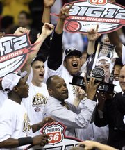 Missouri coach Mike Anderson holds up the Big 12 championship trophy after defeating Baylor 73-60 in the Big 12 Conference men's tournament championship game in Oklahoma City, Saturday, March 14, 2009.