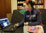 A photo of her parents, Jerry Spangenberg and Ann Allen, sits on the lap of Melissa Spangenberg as she looks at a World of Warcraft Web page Feb. 1 in New York. When her father collapsed and died in the middle of a quest in the online game, Spangenberg embarked on a quest of her own: to let her father’s gaming friends know that he hadn’t just decided to desert them.