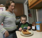 Eleana Walsh watches her son Carter make his peanut butter and jelly sandwich in Bow, N.H., in this Feb. 13, 2009, file photo. The peanut is a national icon — right up there with the hamburger and the apple, but the weeks-long salmonella scare has resulted in a pervasive suspicion of peanuts as a health hazard.