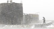 John Schippers prepares to check oil tank batteries south of Hays as a strong winds drive snow creating blizzard conditions and reducing the visibility to less than one-quarter mile in parts of Kansas on Friday.