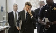 Treasury Secretary Timothy Geithner, center, talks on his mobile phone Thursday as he walks into the House Rayburn Building on Capitol Hill in Washington to appear before the House Financial Services Committee. Geithner unveiled the Obama administration’s plan to expand financial regulations, with skeptics questioning the proposal’s effectiveness.