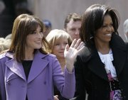 U.S. first lady Michelle Obama, right, and France’s first lady Carla Bruni-Sarkozy wave to onlookers, after they visited Strasbourg Cathedral during the programme for the spouses of NATO leaders Saturday in Strasbourg, France.