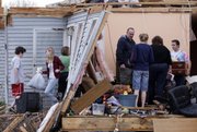 People help sort through debris after the roof and some walls were torn off the home of Billy and Sharon White after severe storms went through Murfreesboro, Tenn., on Friday.