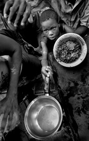 Clayson Menthor, 13, holds out a small pot for some beans and rice provided by a church outside of Cabaret, Haiti. This photo, taken Sept. 9, 2008, is one from a series that earned the 2009 Pulitzer Prize for Breaking News by Miami Herald photographer Patrick Farrell.